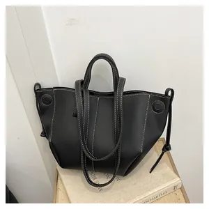 Détail du sac cabas en cuir noir avec coutures blanches contrastées et cordon de serrage