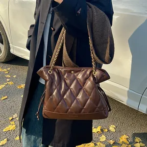Close-up of brown quilted leather bucket bag with gold chain and Fashion & Bags logo