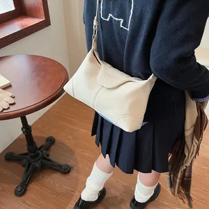 Détail du sac à bandoulière en cuir beige grainé avec bandoulière réglable