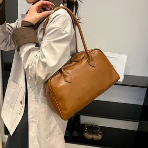 Brown vintage style faux leather tote bag being worn by a model in a lifestyle setting