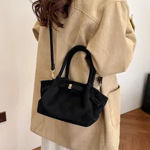 Detail of vintage suede tote bag with leather bow knot and golden metal buckle