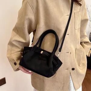 Macro view of black suede texture tote bag featuring metal buckle and premium stitching