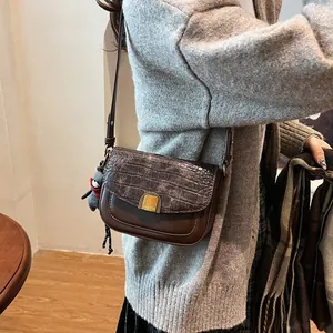 Detail der braunen Retro-Tasche mit Steinstruktur und Plüschbär-Anhänger-Detail