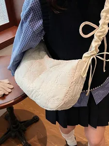 Quilted cream crossbody bag with puffy texture and adjustable drawstring shoulder strap