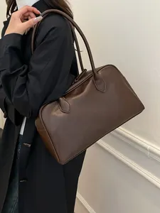 Minimalist dark brown leather shoulder bag with sleek finish and long straps for women