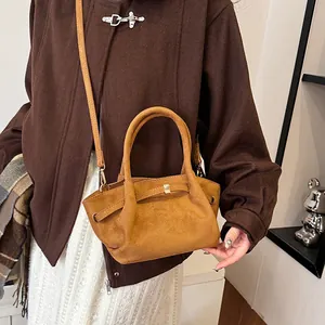Close-up of brown suede tote bag showing premium matte texture and metal buckle detail