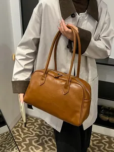 Vintage brown leather tote bag with zip closure and top handles shown on model