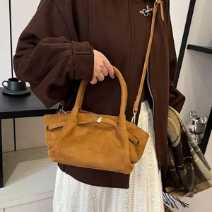 Close-up of khaki brown suede tote bag featuring a minimalist golden metal square buckle