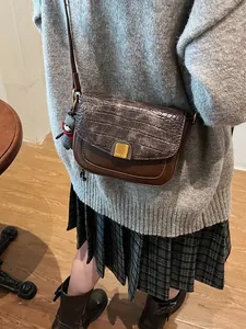 Vintage braune Umhängetasche mit Krokostruktur und Metallschnalle am Casual-Outfit