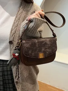 Braune Vintage Umhängetasche mit Krokostruktur und einem süßen Bärenanhänger