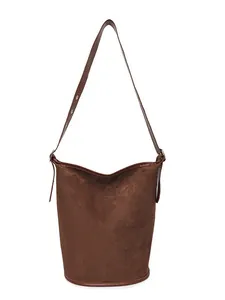 Dark brown matte suede bucket bag with adjustable shoulder strap and gold eyelets