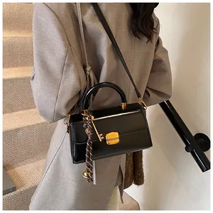 Detailansicht der schwarzen Lederhandtasche mit goldenem Schlüsselanhänger und Kordel