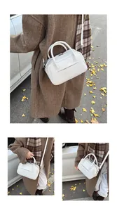 Three-way view of a white Boston style faux leather handbag styled with an autumn outfit