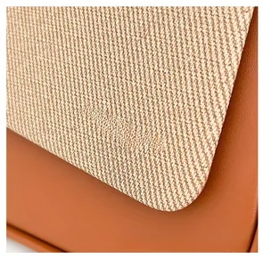 Détail du sac vintage montrant le tissu en sergé beige et le cuir orange-marron