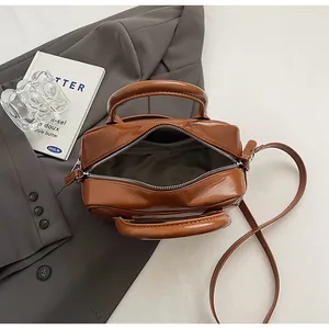 Detailed top view of caramel leather bag interior with zipper and adjustable strap