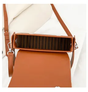 Vue de dessus du sac en cuir marron montrant l'intérieur en accordéon et fermoir argent