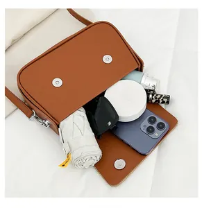 Détail de la capacité intérieure du sac à bandoulière marron avec espace de rangement pratique