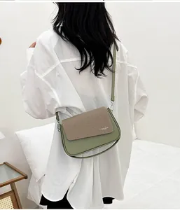 Détail du sac bandoulière vert olive avec rabat texturé sur mannequin en chemise