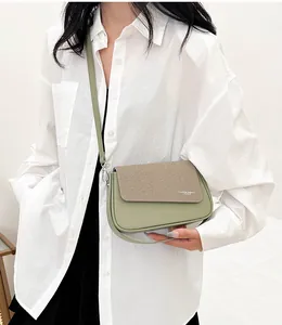 Détail d'un sac bandoulière bicolore vert sauge en similicuir et rabat en tissu beige