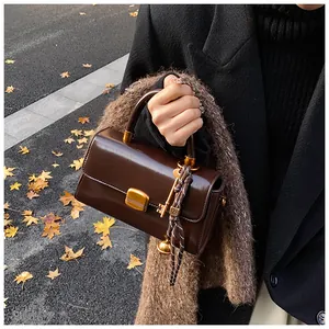 Detailansicht der dunkelbraunen Vintage-Handtasche aus Kunstleder mit Goldverschluss