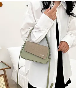 Détail du sac à bandoulière carré bicolore en vert sauge et beige aspect tressé