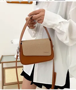Détail du sac à main carré avec cuir marron et rabat en tissu sergé de couleur kaki