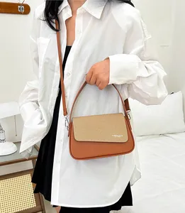 Détail des coutures en cuir marron et texture beige sur ce sac à bandoulière très élégant