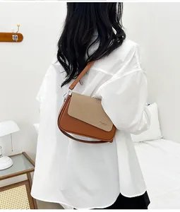 Détail du rabat tissé et du cuir marron sur ce sac à bandoulière élégant et moderne