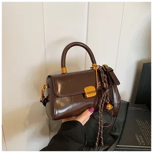 Detail der braunen Vintage-Ölwachs-Ledertasche mit goldenem Schloss und Anhänger