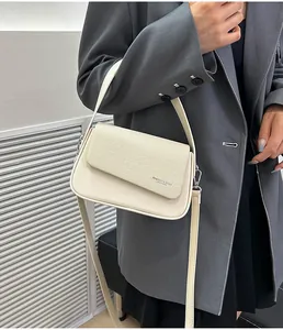 Détail du sac crème avec panneau à texture tissée et design à double bandoulière
