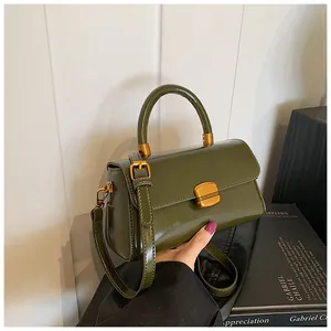 Nahaufnahme der dunkelgrünen Vintage Lederhandtasche mit goldenem Drehverschluss und Griff