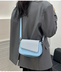 Détail du patchwork en tissu bleu clair et gris sur un sac à bandoulière chic