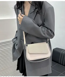 Détail du sac bandoulière crème avec rabat kaki texturé et boucle métallique élégante