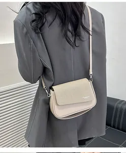 Détail du rabat texturé et du cuir lisse sur ce petit sac bandoulière beige pour femme