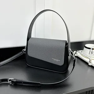 Détail du sac à main bicolore avec rabat gris texturé et finition en cuir noir