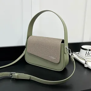 Détail d'un sac à main vert en similicuir avec rabat marron et garnitures métalliques