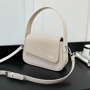 Détail de la texture tissée et du cuir beige sur ce sac à main carré tendance