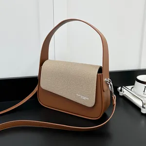 Détail du sac à main en cuir marron avec rabat tissé et garnitures en argent poli