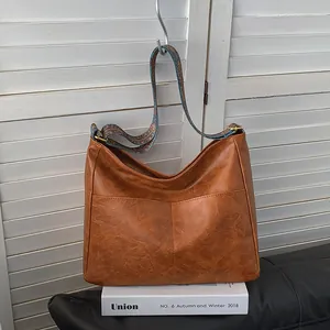 Detail einer braunen Hobo-Tasche mit breitem Gurt im ethnischen Vintage-Stil