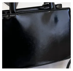 Close-up of premium black patent leather texture on a stylish tote handbag
