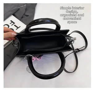 Interior view of black tote bag showing main compartment, zipper pocket and lining