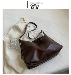 Detail view of large coffee brown tote bag on white fabric with neutral aesthetic