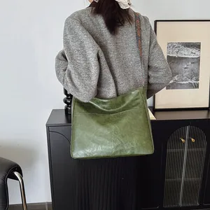 Detailansicht der grünen Hobo-Tasche mit gewebtem Schultergurt im ethnischen Boho-Stil