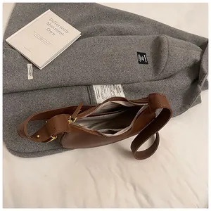 Interno della borsa a mezzaluna in pelle marrone con finiture dorate e fodera in tessuto