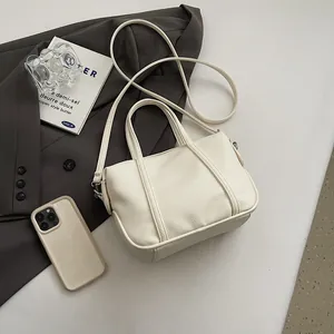 Close-up of cream-white lychee texture faux leather handbag with shoulder strap and handle