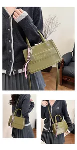 Detailed views of a dark green patent leather square tote bag with decorative charms