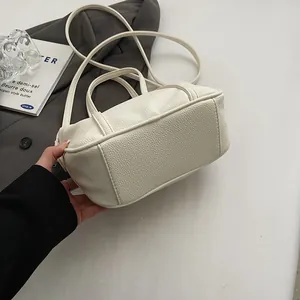Close-up of cream lychee texture faux leather handbag with reinforced stitching and handle