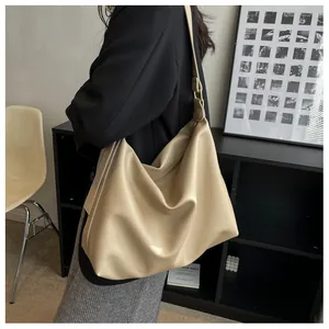 Detail of beige leather tote bag with adjustable wide strap and gold hardware