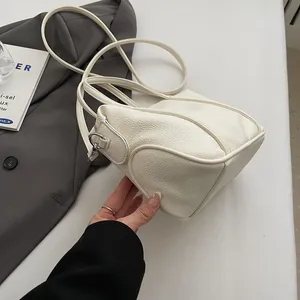 Close-up of premium white lychee grain leather handbag with silver metallic buckle detail