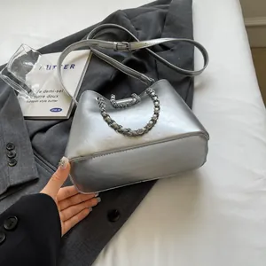 Close-up of stylish silver bucket bag with metallic finish and decorative chain detail